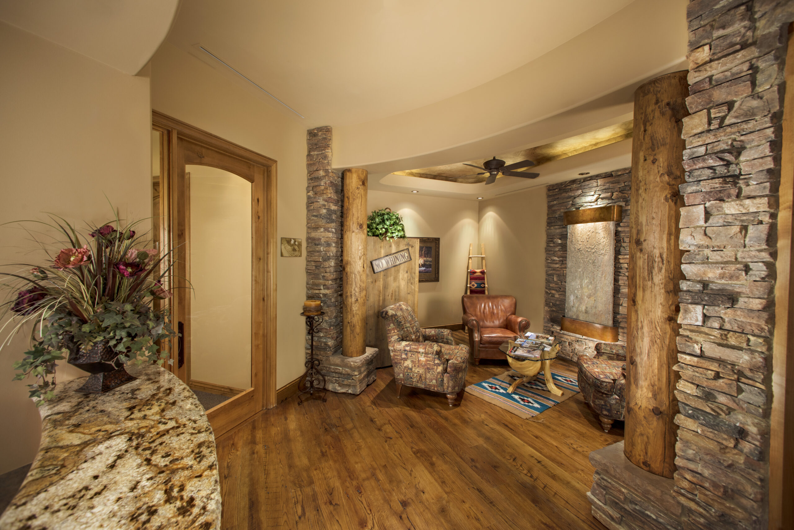 Modern dental office reception area with wood flooring, stone accents, and welcoming décor.