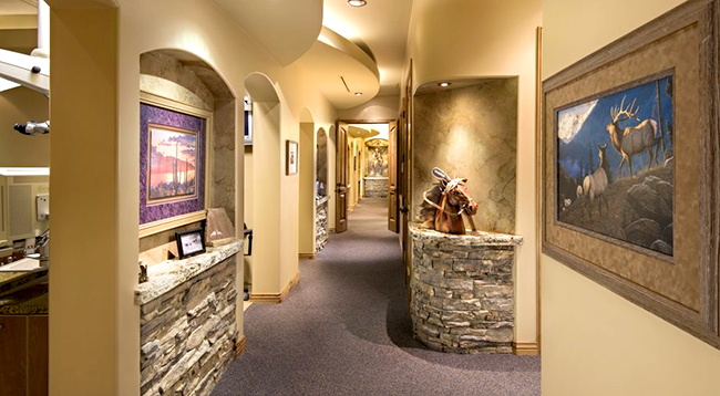 Modern dental office hallway with warm lighting, artwork, and professional interior design.
